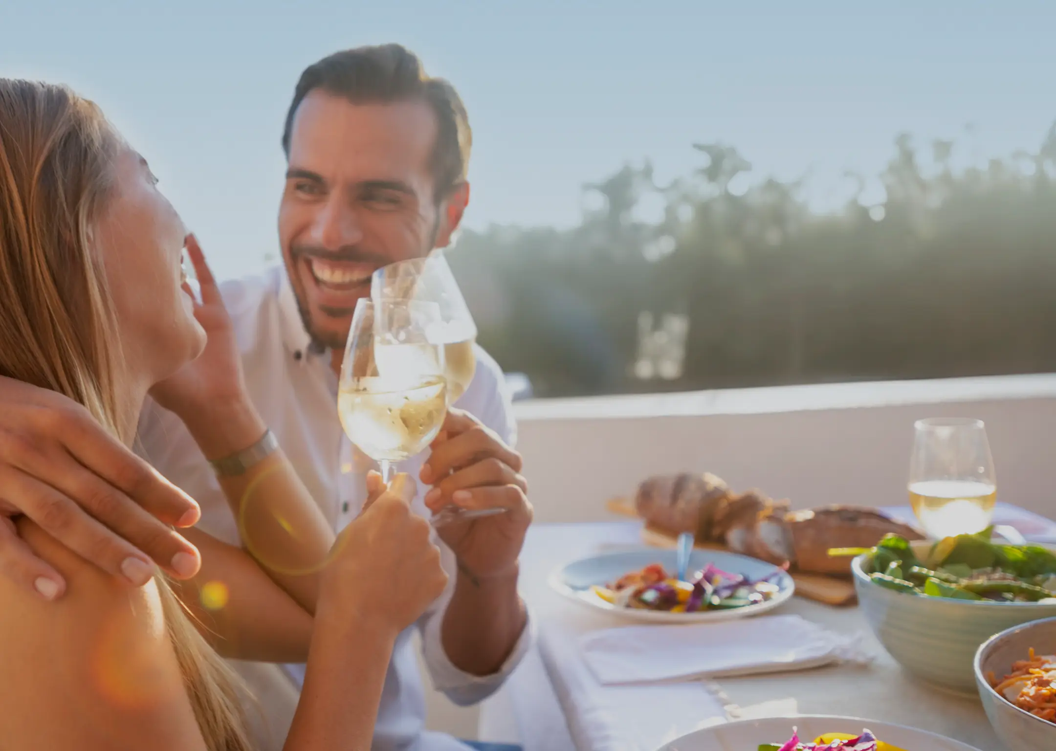 Happy couple dining alfresco with friends