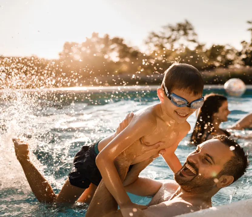 Father and son playing in Bespoke swimming pool in spa garden of home