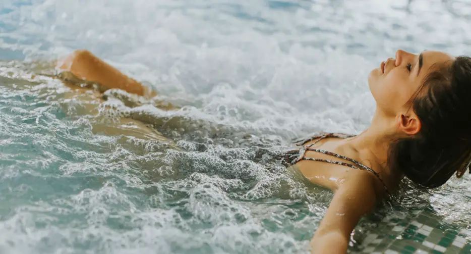 Women relaxing in custom designed hydropool in garden of luxury private home