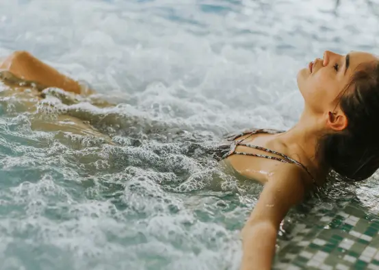 Women relaxing in custom designed hydropool in garden of luxury private home