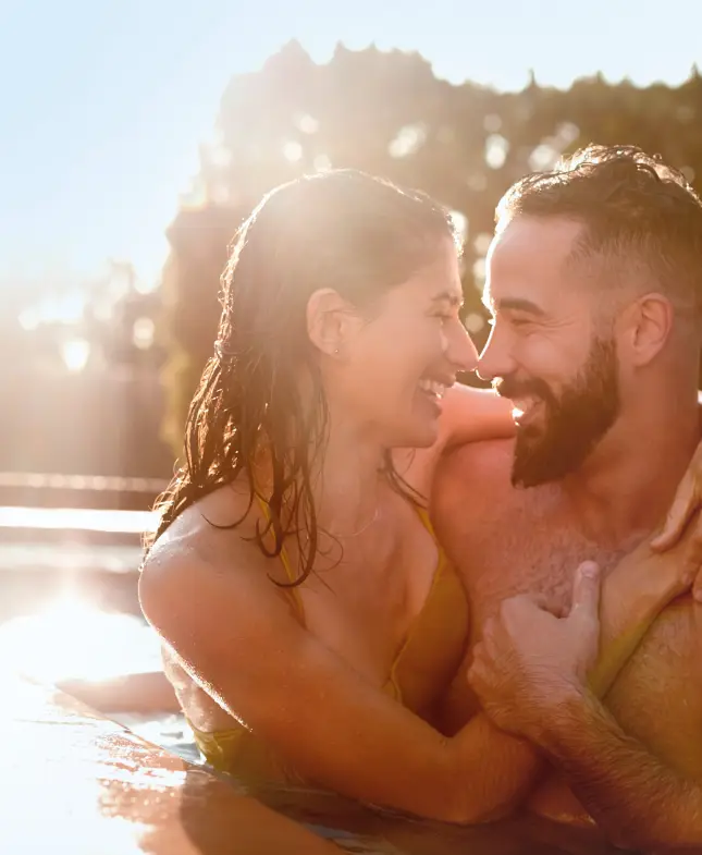 Happy couple is luxury swimming pool spa