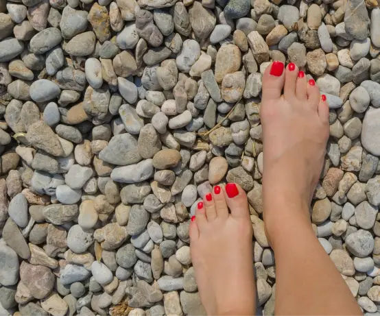 Women walking on pebble reflexology path for health benefits