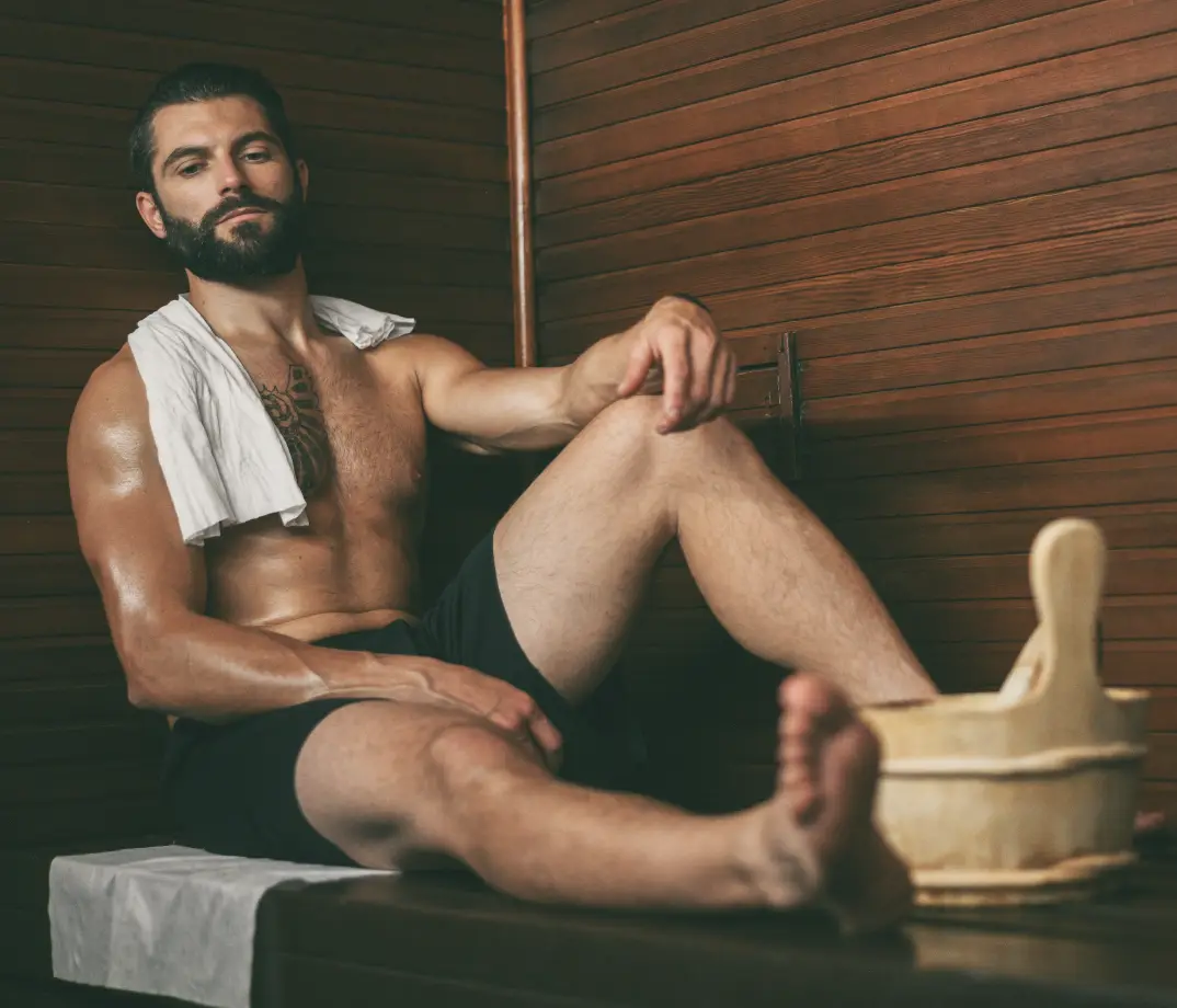 Althletic man in sauna to aid sports recovery